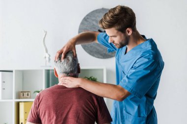klinikte orta yaşlı hastanın başkanı na dokunmadan yakışıklı doktor