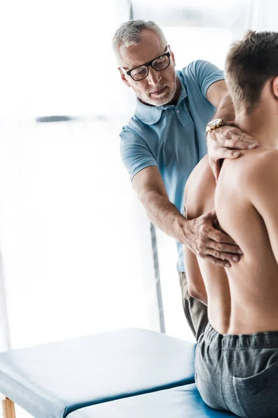Médico Barbudo Gafas Tocando Espalda Del Paciente Muscular Clínica — Foto de Stock