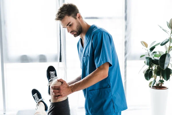 Όμορφος Γιατρός Αγγίζοντας Πόδι Του Ώριμου Ασθενούς — Φωτογραφία Αρχείου