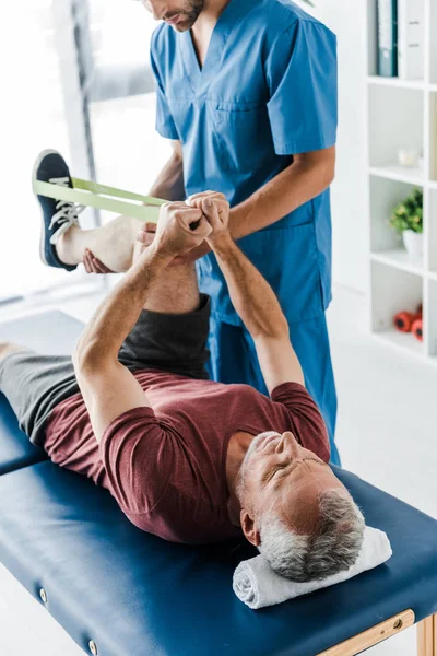 Beskuren Över Skäggiga Läkare Som Håller Benet Mogen Patient Utövar — Stockfoto