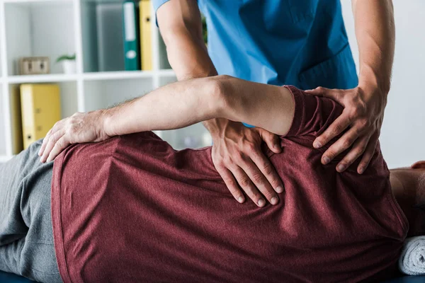 Abgeschnittene Ansicht Von Arzt Berührt Reifen Mann Liegend Auf Massagetisch — Stockfoto