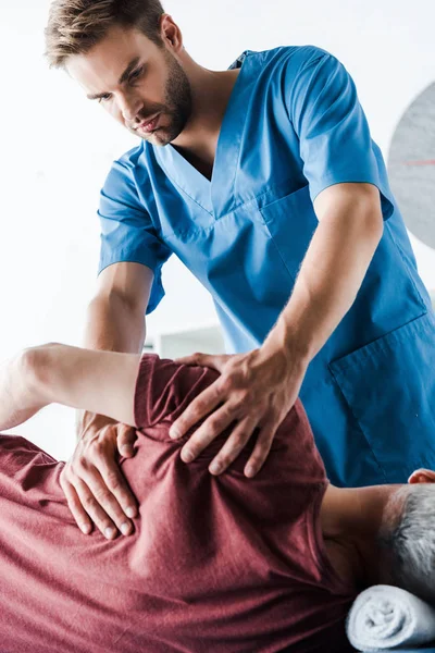 Médico Tocando Homem Maduro Deitado Mesa Massagem — Fotografia de Stock