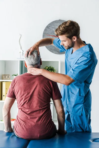 Pohledný Vousatý Doktor Dotýkal Hlavy Středního Pacienta Klinice — Stock fotografie