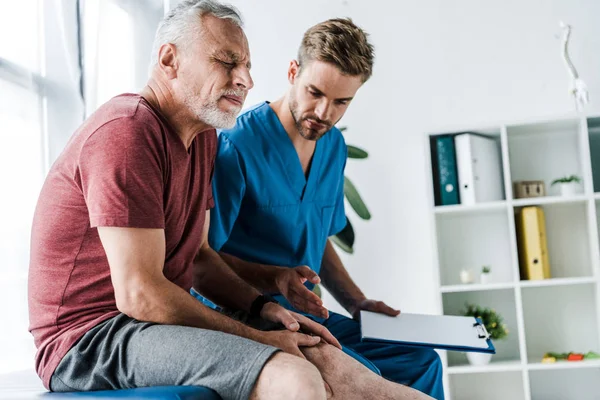 Bärtige Reife Patientin Mit Geschlossenen Augen Berührt Bein Der Nähe — Stockfoto