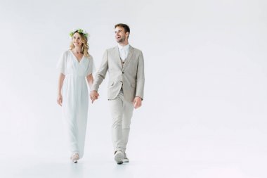 çekici gelin ve yakışıklı damat el ele tutuşarak ve uzağa bakıyor