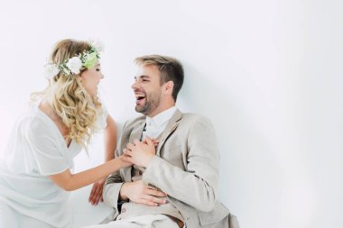 çekici gelin ve yakışıklı damat el ele tutuşarak ve birbirlerine bakıyor 