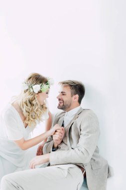 çekici gelin ve yakışıklı damat el ele tutuşarak ve birbirlerine bakıyor 