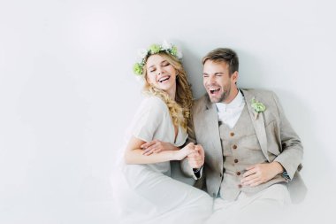 çekici gelin ve yakışıklı damat el ele tutuşarak ve uzağa bakıyor 