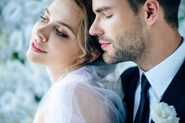 kapalı gözlü takım elbiseli çekici gelin ve yakışıklı damat 