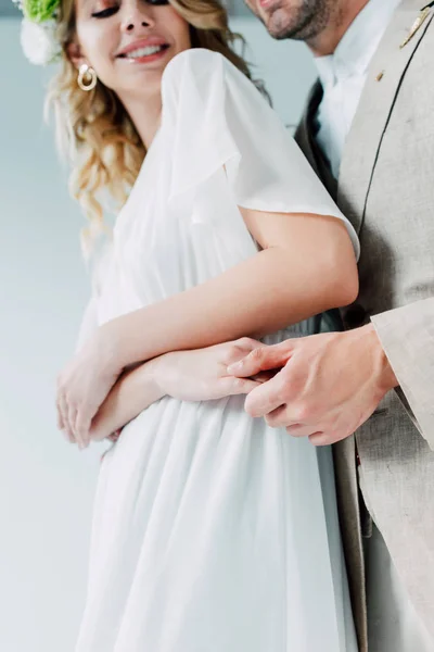 灰色に隔離された花婿の笑顔と手を握るトリミングされたビュー — ストック写真