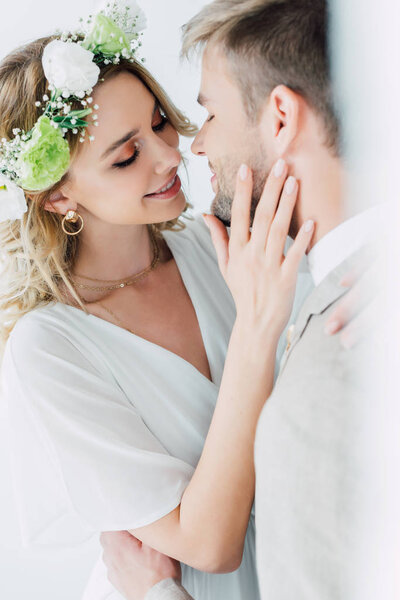 attractive bride and handsome bridegroom hugging and kissing with closed eyes 