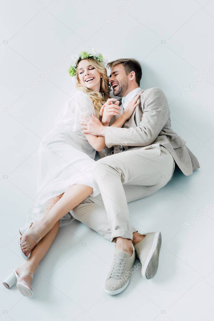 attractive bride and handsome bridegroom hugging and looking away 