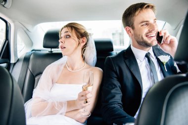 çekici gelin uzakta bakıyor ve yakışıklı damat akıllı telefon konuşuyor 