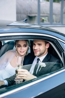 çekici gelin ve yakışıklı damat şampanya bardakları tutan