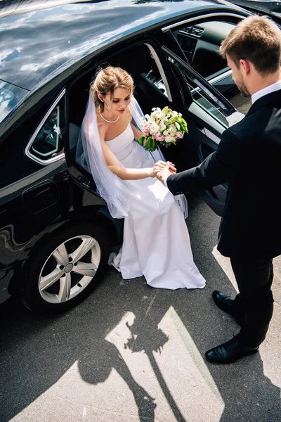 Bruidegom Pak Geven Hand Aan Aantrekkelijke Lachende Bruid Met Boeket — Stockfoto