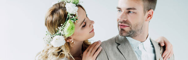 panoramic shot of attractive bride and handsome bridegroom looking at each other 