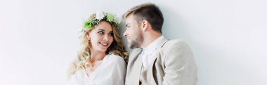 çekici gelin ve yakışıklı damat panoramik çekim gülümseyerek ve birbirlerine bakarak 