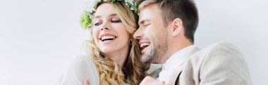 çekici gelin ve yakışıklı damat panoramik çekim gülümseyerek ve uzakta beyaz izole bakıyor 