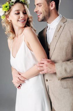 takım elbise yakışıklı damat gelinlik ve çelenk gri izole gelin ile sarılma