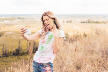 t-shirt çekici kadın selfie alarak ve rock işareti gösteren