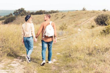 dışarıda el ele tutuşan kadın ve erkeğin arka görünümü 