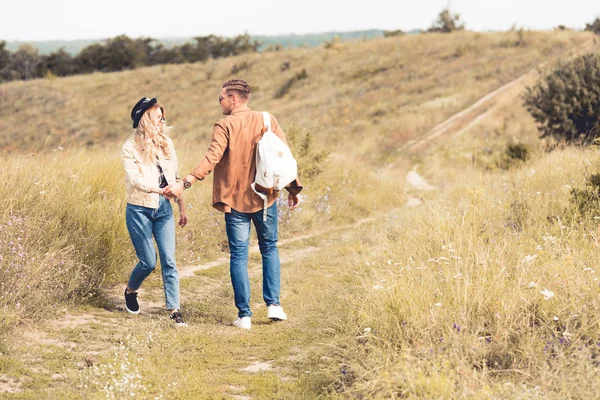dışarıda el ele tutuşan kadın ve erkeğin arka görünümü 