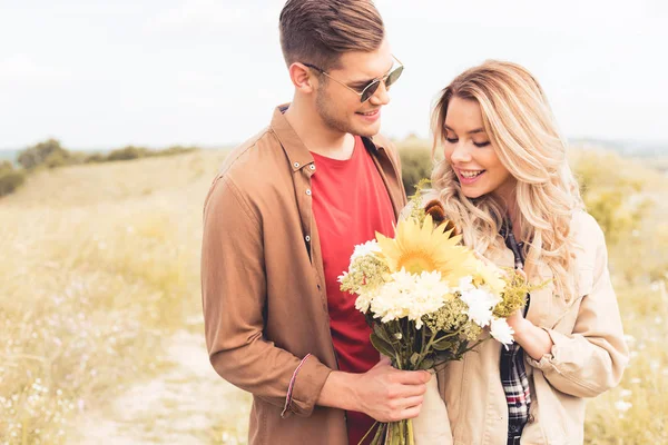 Schöner Mann Mit Brille Schenkt Blonder Frau Blumenstrauß — Stockfoto