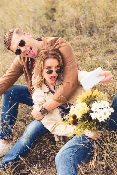 自分撮りを取る花束とハンサムな男性と魅力的な女性 — ストック写真