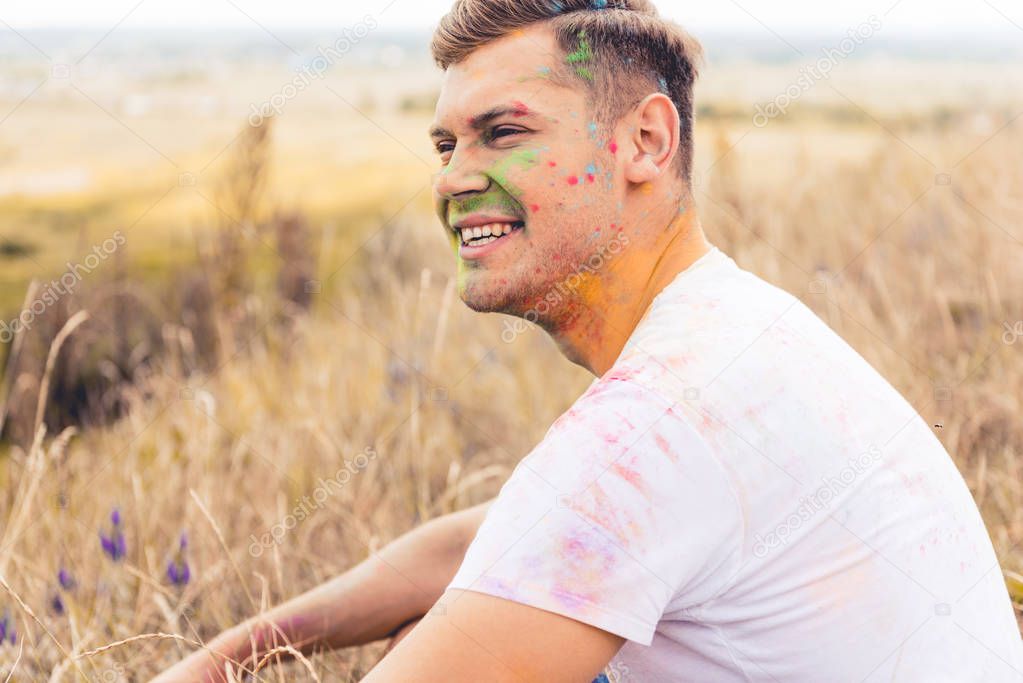 handsome man in t-shirt smiling and looking away outside 