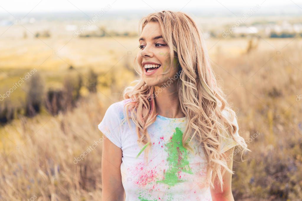 attractive woman in t-shirt smiling and looking away outside 