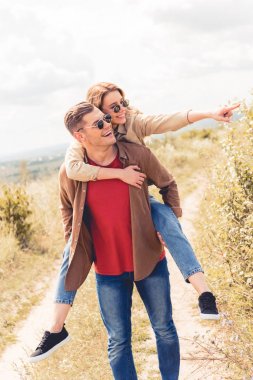 yakışıklı adam dışında onun çekici ve sarışın kız arkadaşı piggybacking 