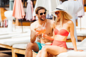 glückliches lächelndes Paar bei Cocktails im Resort an einem sonnigen Tag