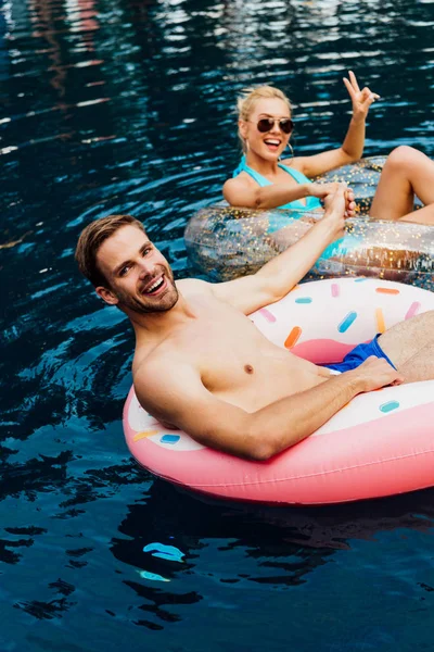 Smiling Couple Holding Hands While Lying Swim Rings Swimming Pool — Stock Photo, Image