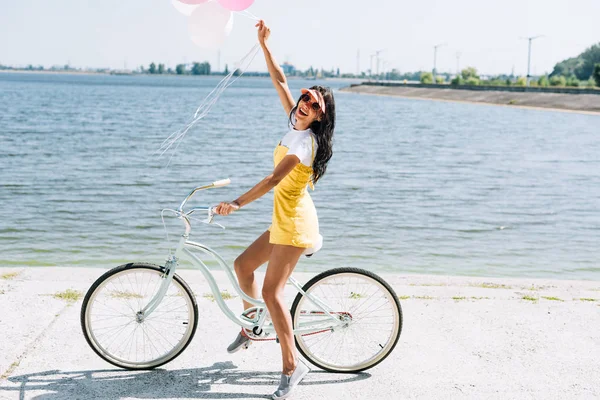 Vista Lateral Chica Morena Feliz Montar Bicicleta Con Globos Cerca —  Fotos de Stock