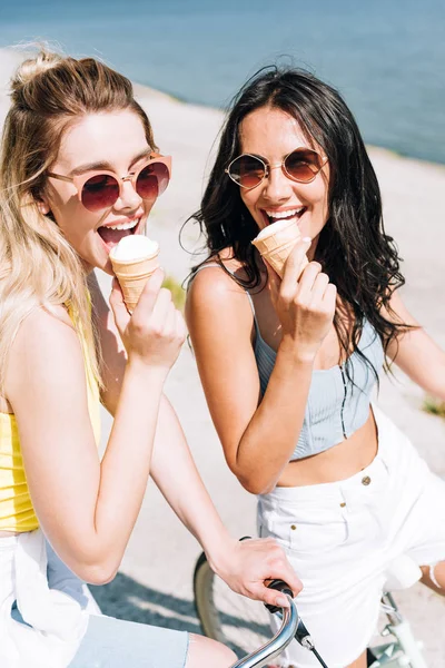 Happy Blonde Brunette Girls Riding Bikes Eating Ice Cream — Stock Photo, Image