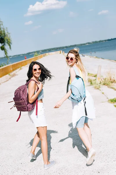 Meninas Alegres Andando Com Mochilas Perto Rio Verão — Fotografia de Stock