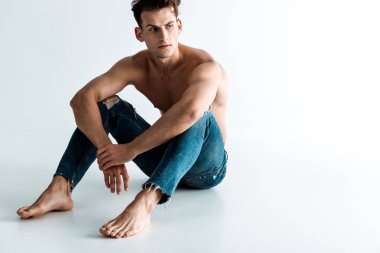 beyaz yalınayak oturan seksi genç adam 