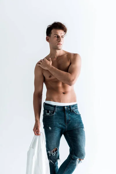 Sexy Man Holding Shirt Och Stående Isolerad Vitt — Stockfoto