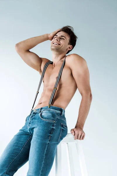 Homem Feliz Muscular Tocando Cabelo Perto Cadeira Branco — Fotografia de Stock