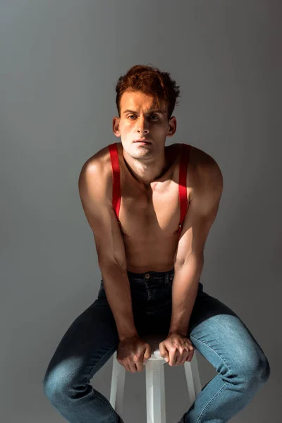 Hombre Sin Camisa Tirantes Rojos Mirando Cámara Sentado Una Silla —  Fotos de Stock