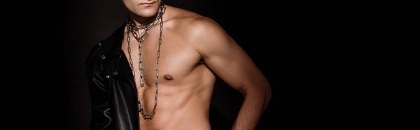 панорамный снимок мускулистого человека с цепями на шее, изолированными на черном
 