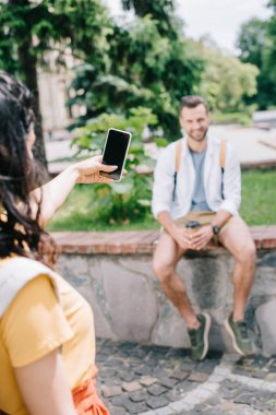 erkeğin yanında boş ekranile akıllı telefon tutan kadının seçici odak 