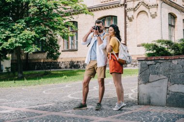 kadının yanında fotoğraf çekerken yüzü kaplayan adam 