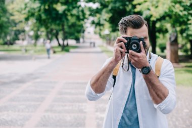 dijital fotoğraf makinesinde fotoğraf çekerken yüzü kaplayan adam 