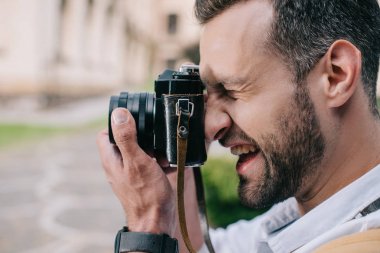 dijital fotoğraf makinesinde fotoğraf çeken mutlu adam yan görünümü 