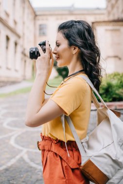 fotoğraf çekerken dijital fotoğraf makinesi tutan güzel kız yan görünümü 