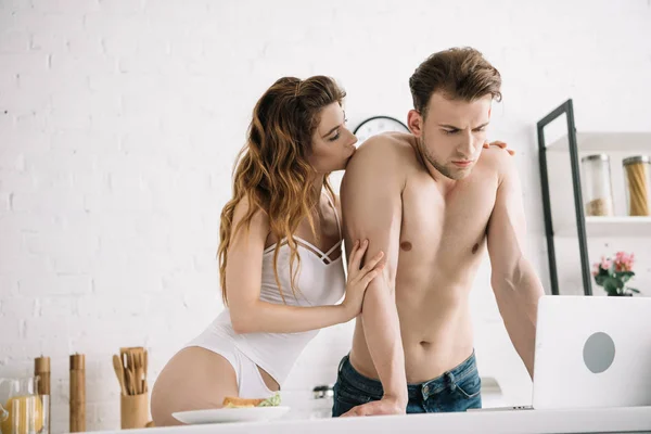 Attractive Woman Hugging Handsome Boyfriend Using Laptop Apartment — Stock Photo, Image