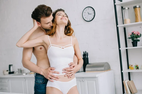 Knappe Vriendje Knuffelen Aantrekkelijke Vriendin Met Gesloten Ogen Appartement — Stockfoto