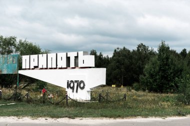 Pripyat, Ukrayna - 15 Ağustos 2019: dışarıdaki ağaçların yanında pripyat harfleri olan anıt 
