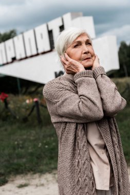 Pripyat, Ukrayna - 15 Ağustos 2019: pripyat harfleri ve kulakları kapsayan anıtın yakınında emekli kadın 